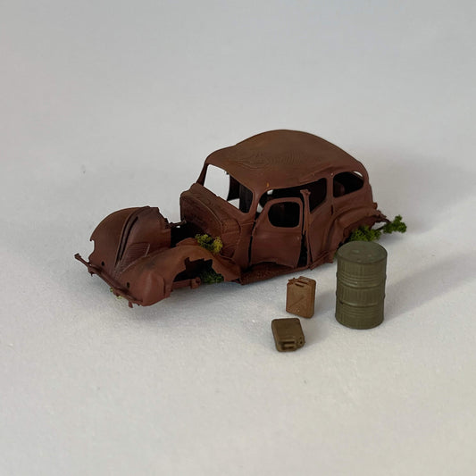 Épave voiture rétro abandonnée avec 2 jerrican et un fût